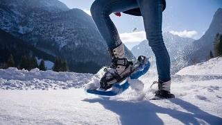 年轻女子在山腰穿雪鞋视频素材模板下载