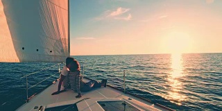 日落时分，一对夫妇在一艘帆船的甲板上休息