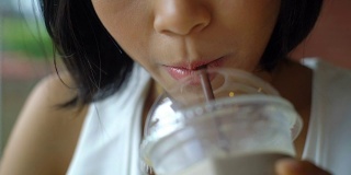 年轻的亚洲女士喝冰咖啡特写