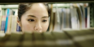亚洲学生在图书馆看书。