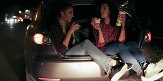 帅气的女朋友会坐在汽车的敞篷后备箱里，一边聊天，一边吃三明治，在城里的夜晚用纸杯喝水。Slowmotion拍摄