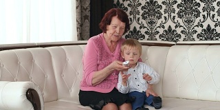 奶奶和孙子用遥控器换频道。