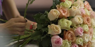 美丽的玫瑰在女性手中，花商做了一束