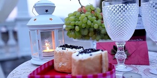 浪漫烛光晚餐的装饰品。烛光，灯笼，蛋糕和水果，浪漫的两人晚餐