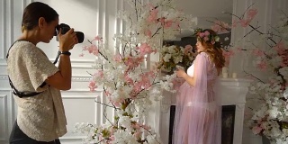 摄影师拍摄孕妇捧花和壁炉的背景