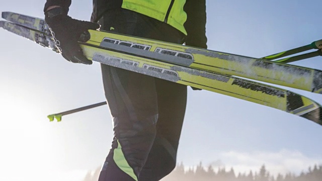 越野滑雪者在冬季景观携带他的运动设备