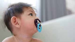 亚洲小孩婴儿奶嘴安抚奶嘴奇特的吸血鬼牙齿吸血鬼怪物视频素材模板下载