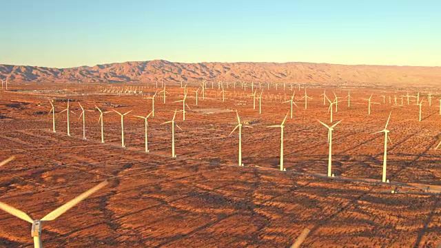 鸟瞰图风力涡轮机在日落旋转，清洁可持续的可再生能源
