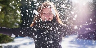 年轻女子向空中抛雪