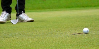 超级慢动作高尔夫球手把球洞给赢家在美丽的高尔夫球场