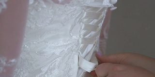 妈妈帮新娘穿婚纱。