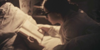 年轻女子在床上读旧书-深夜