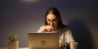 认真的年轻学生用电脑学习，女人工作到很晚