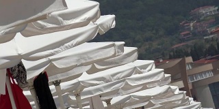 白色沙滩遮阳伞在海滨排队