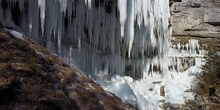 空中特写:令人惊叹的冰柱上的山瀑布墙在冬天