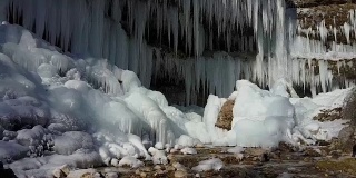 在阳光明媚的冬天，空中的山河在令人惊叹的白色冰柱下流动