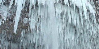 近距离观察:山上的河流瀑布在冬天结冰成许多白色的冰柱