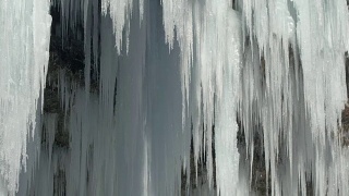 特写:早春的阳光融化了令人惊叹的冰柱，水滴滴落下来视频素材模板下载