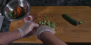 专业厨师在商用厨房用手套切黄瓜