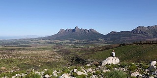 人们坐在岩石上欣赏风景