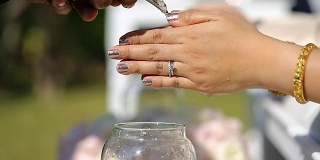 泰国婚礼，双手将祝福水注入新娘的手带。
