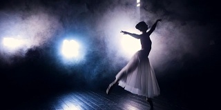 芭蕾舞演员在人造的舞台雾中跳舞。
