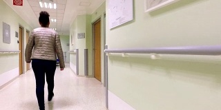 年轻的女病人走在医院的走廊上