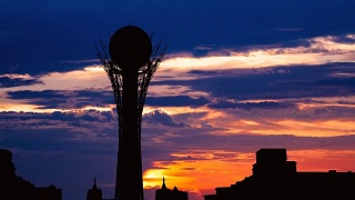 在哈萨克斯坦首都阿斯塔纳美丽的日落上，Bayterek塔的剪影视频素材模板下载