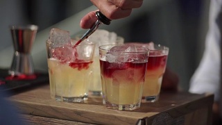 慢动作镜头的一个调酒师在一个户外酒吧倒鸡尾酒到一个杯子视频素材模板下载