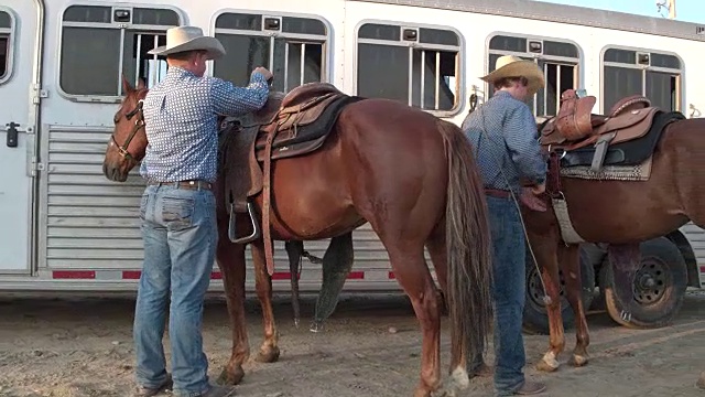两个牛仔准备他们的马骑马在犹他州，美国