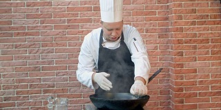 餐厅厨师用平底锅煎海鲜饺，榨柠檬汁