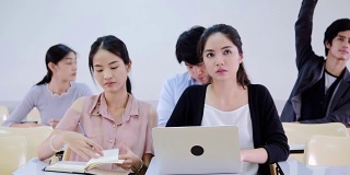 一堂关于大学的课在听老师讲课，亚洲学生正在学习。
