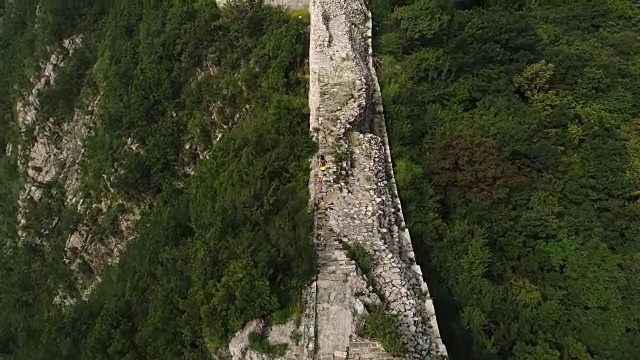 鸟瞰图的年轻的健身妇女越野跑跑在长城的顶端