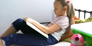 小女生在床上看书。