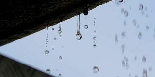 慢镜头:近距离观察，水滴从屋檐落下