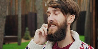 一个留着胡子的男人在讲电话
