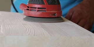 木匠打磨一个木制台阶与电动砂光机车间特写