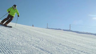 慢动作跟踪完美的雪道与滑雪者雕刻下斜坡视频素材模板下载
