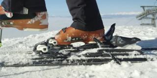 慢动作接近:滑雪者步骤在滑雪绑定与滑雪靴在度假村在阿尔卑斯山