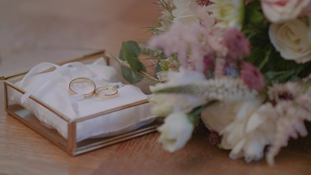 结婚戒指装饰盒与鲜花背景。