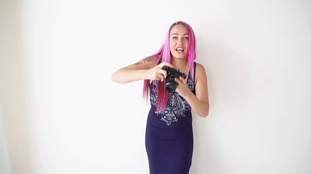 粉色头发的女孩用老式相机拍照