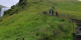 游客走在冰岛skogafoss瀑布的楼梯上，慢镜头