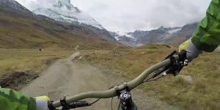 骑山地自行车的人沿着远处标志性的山下山