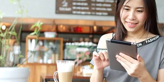 女性在咖啡馆使用平板电脑