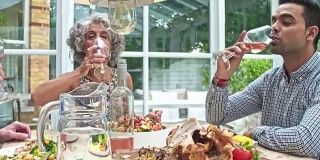 朋友们在家里吃午餐时用葡萄酒敬酒的实时视频
