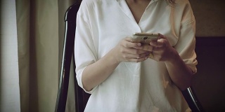一名年轻女子在咖啡馆使用智能手机。
