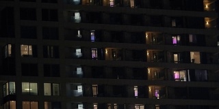 多层住宅或酒店的夜景，窗户有灯光
