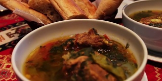 美味的阿塞拜疆民族羊肉汤在餐厅。以面包玉米饼为背景的白色盘子里的肉汤