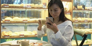 成熟的女人在咖啡店用手机
