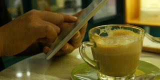 人类的手在咖啡店使用手机